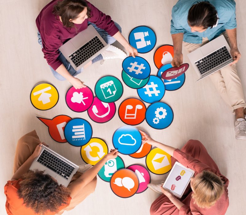 Group of zoobea working together with social media icons on table" Digital Marketing Agency in UK & USA