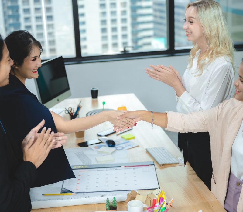 Two Zoobea businesswomen shaking hands in office meeting"Digital Marketing Agency in UK & USA